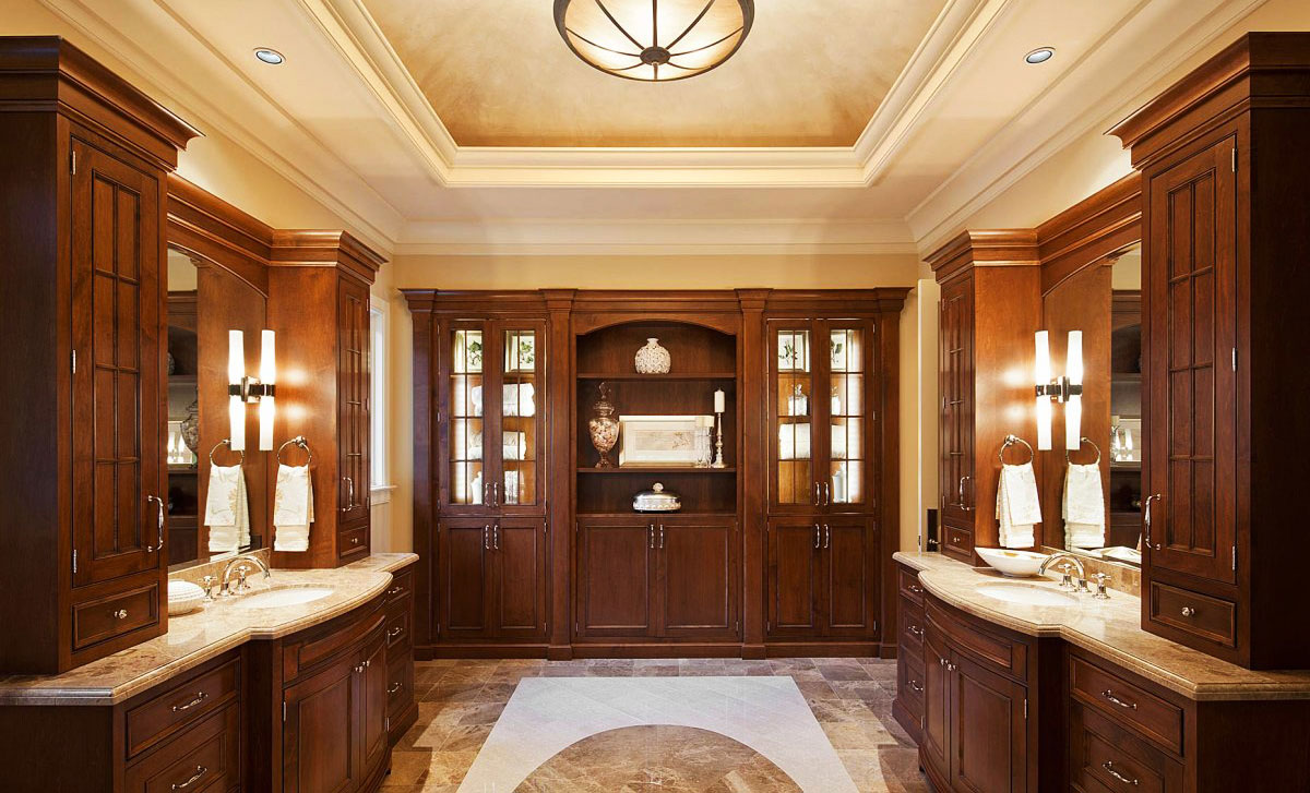 Ekskluzywna łazienka: klasyczne, drewniane meble, komody łazienkowe z marmurowymi blatami, duży regał i okrągły żyrandol